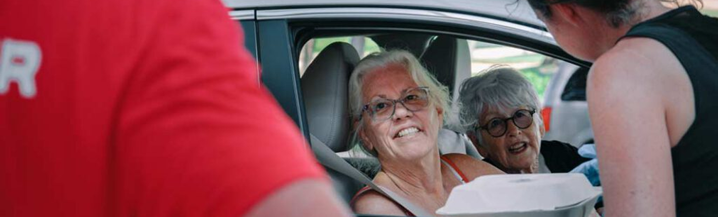 Disaster relief volunteers helping community members at car distribution